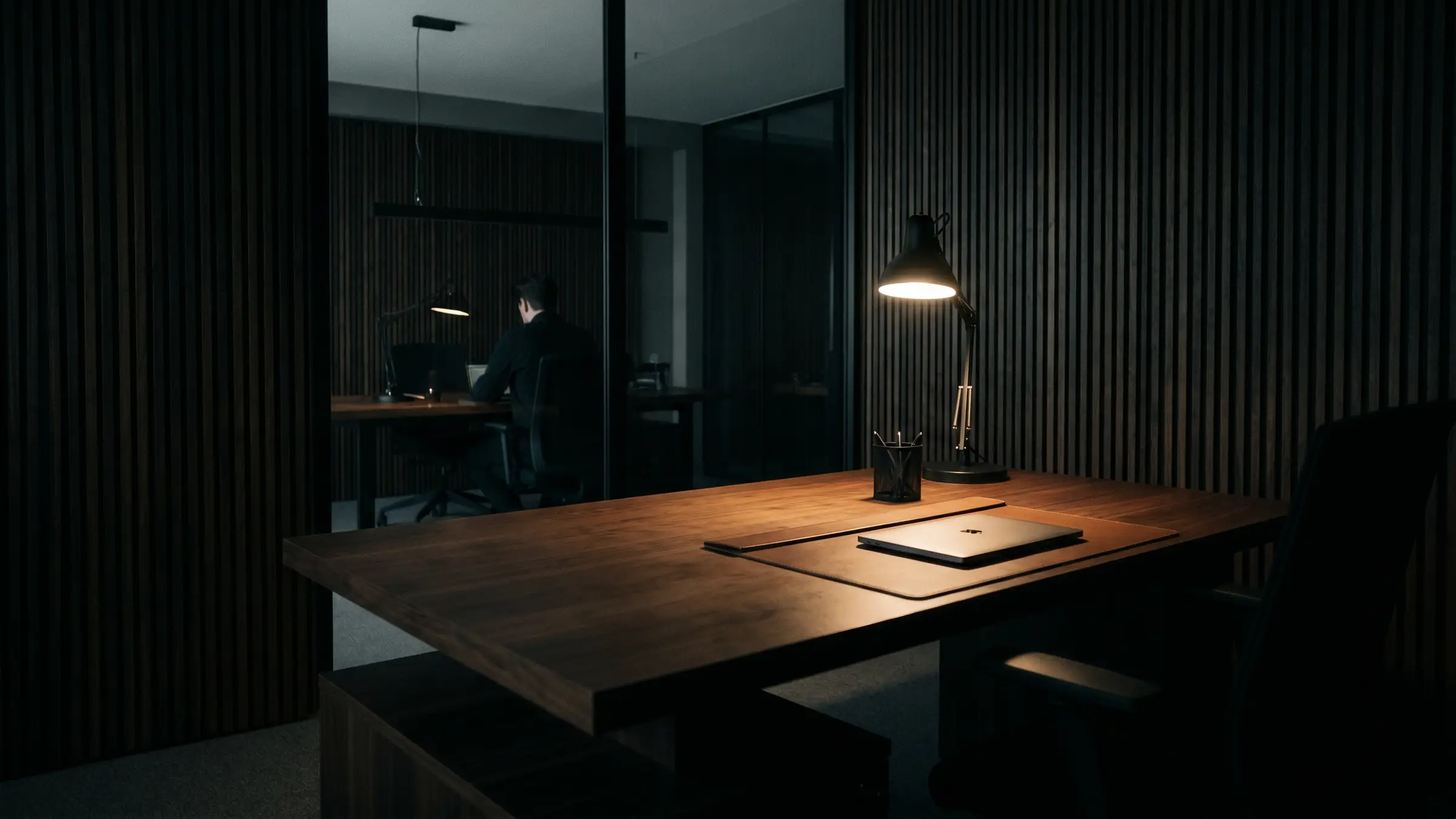 A dark, calm studio interior in low, cinematic light.